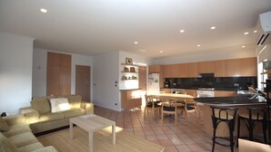 A modern apartment with a living room, dining area, and kitchen.