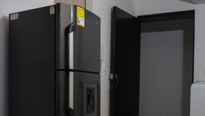 Une cuisine moderne avec un réfrigérateur noir, un four à micro-ondes et une cuisinière.