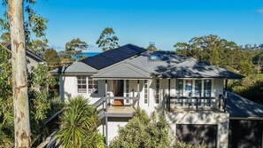 A two-story house with a balcony, solar panels, and a garage.