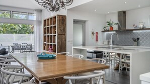 A modern kitchen with a central island, white cabinetry, and a view of the outdoors.