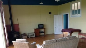 A living room with a sofa, a television, a small table, and a window.