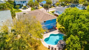 A residential area with a swimming pool surrounded by lush greenery and a view of the ocean. - Blue Sky | Two Units | Pool w/Heating Option | Across from Beach Access (Folly Beach)
