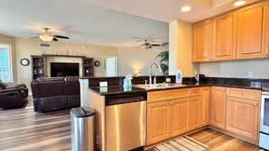 A modern kitchen with wooden cabinets, a dishwasher, and a built-in oven.