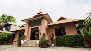A modern building with a prominent entrance, large windows, and a tiled roof.