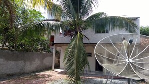 Un quartier résidentiel avec une antenne parabolique, un palmier et un bâtiment doté d’un toit en pente.