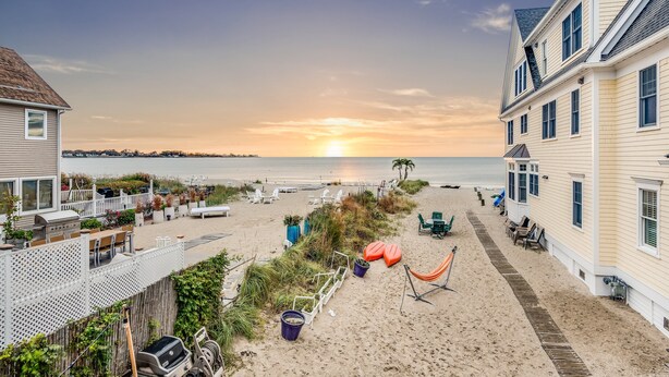Een accommodatie aan het strand met een terras, buitenmeubels en uitzicht op zee.