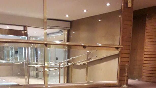 Un interno moderno con un tavolo in vetro, pavimento in legno e una scala.