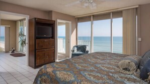 Un dormitorio con una cama grande, televisión y vista al océano.