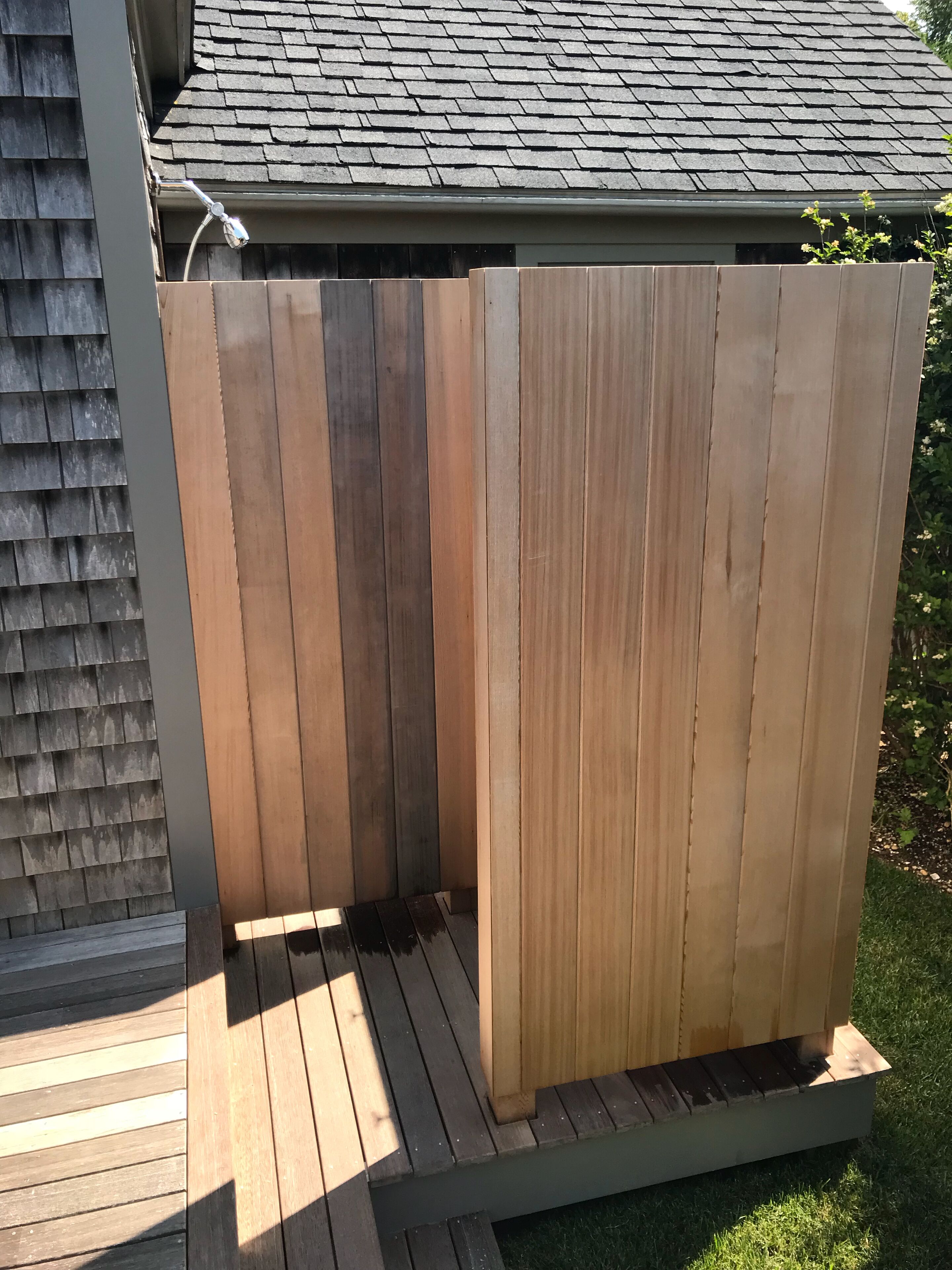 Eine Holzterrasse mit integriertem Duschbereich.