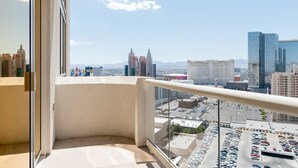 A balcony with a city view, including high-rise buildings and a parking lot. - True 1BR  Strip View at MGM Signature (Las Vegas)