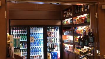A gift shop with shelves stocked with bottled water, snacks, and wine.