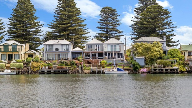 A waterfront property with multiple houses, a dock, and a boat. - The Moorings - Absolute River Frontage (Port Fairy)
