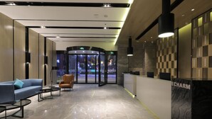 A modern lobby with a reception desk, seating area, and glass doors leading to an outdoor area. - ECHARM HOTEL（Xi Qiao Shan, Foshan） (Foshan)
