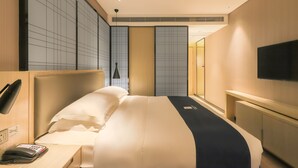 A hotel room with a large bed, bedside table with a phone, a flat-screen TV mounted on the wall, and a large window. - ECHARM HOTEL（Xi Qiao Shan, Foshan） (Foshan)