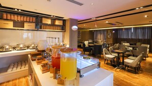 A breakfast bar with various food items and beverages, a seating area with tables and chairs, and a modern interior design. - ECHARM HOTEL（Xi Qiao Shan, Foshan） (Foshan)