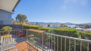 A balcony with a view of a lake, mountains, and a red car parked outside. - Boronia - 7/30 Nettin Circuit (Jindabyne)