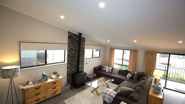 A modern living room with a fireplace, a sofa set, a coffee table, and a lamp. - Boronia - 7/30 Nettin Circuit (Jindabyne)