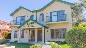 Un bâtiment à deux étages sur lequel on peut lire l’inscription « Cobb & Co. ». Le bâtiment a un toit plat, de nombreuses fenêtres et un petit balcon à l’étage supérieur.
