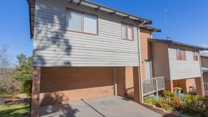 A two-story residential building with a brick foundation and siding. - Lodge 67 - 3/58 Townsend Street (Jindabyne)