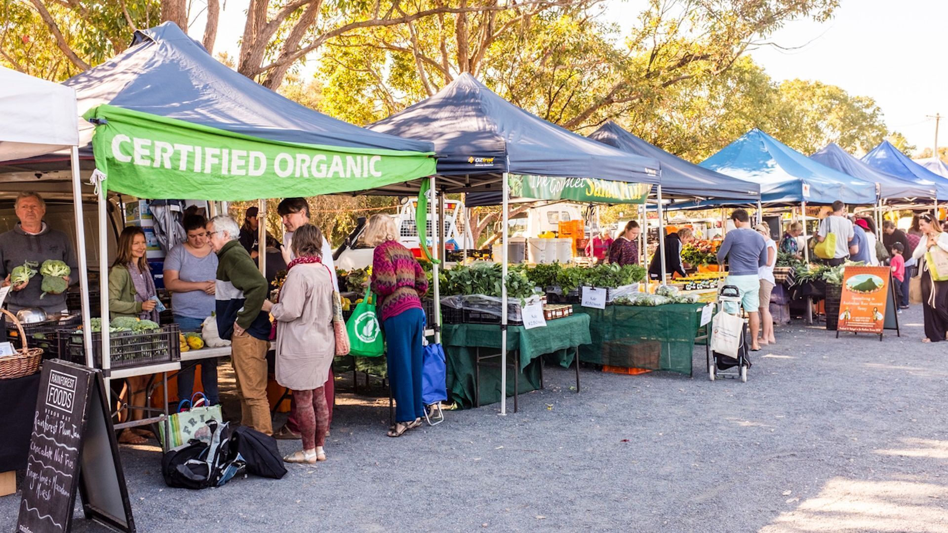 A market with multiple stalls, some labeled "CERTIFIED ORGANIC."