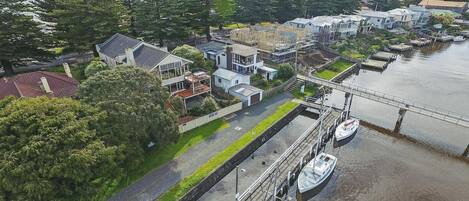 An aerial view of a residential area with houses, a bridge, and a canal with boats.