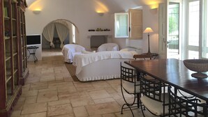 Ein gemütliches Schlafzimmer mit zwei Betten, einem Esstisch und einem Fernseher.