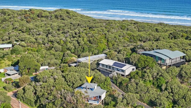 An aerial view of a residential area with multiple houses, a bridge, and a coastline. - 6 Acacia St Sandy Point (Sandy Point)