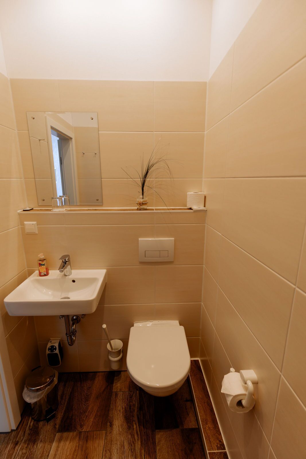 A bathroom with a sink, toilet, and mirror.