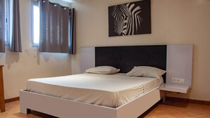 A modern bedroom with a white bed, a headboard, and a wall-mounted zebra print. - Maison D'hote O Panoramic (Dakar)