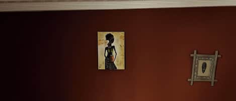 Un dormitorio con una cama grande, dos mesitas de noche, una lámpara de noche y un cuadro en la pared.