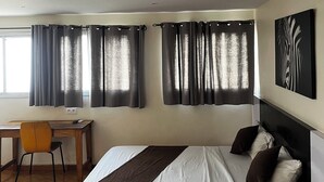 A hotel room with a bed, a desk, and a chair. - Maison D'hote O Panoramic (Dakar)