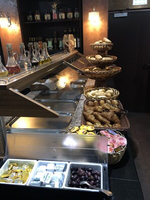A buffet with various food items and condiments. - Hotel & Restaurant Poseidon (Bayreuth)