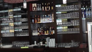 A bar area with shelves stocked with various bottles and glasses. - Hotel & Restaurant Poseidon (Bayreuth)