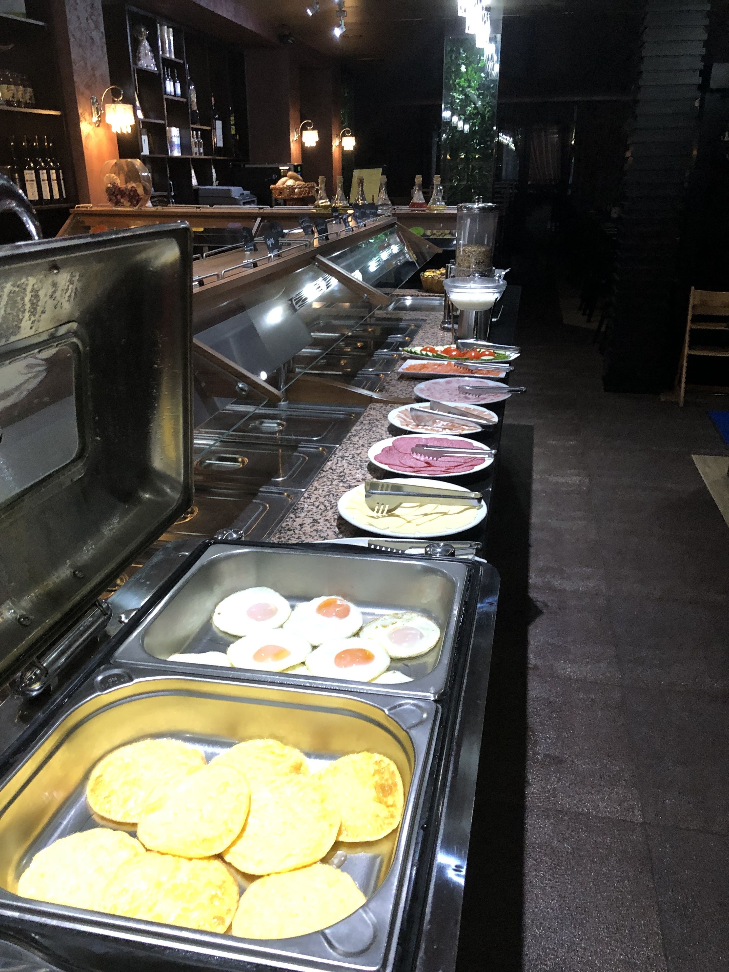 Un buffet proposant une variété de plats et un bar avec des bouteilles et des verres.