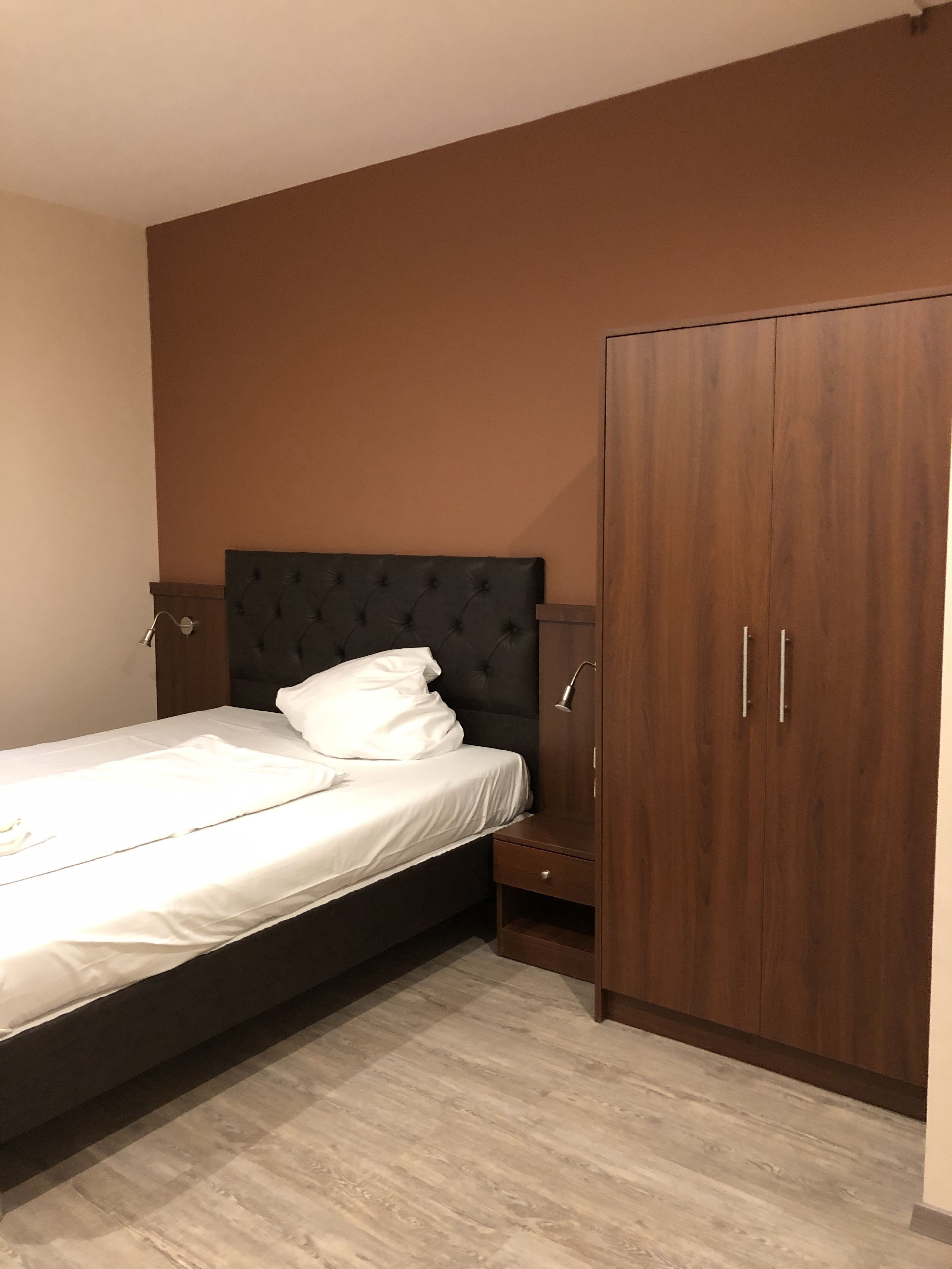 Une chambre à coucher avec un lit, une armoire et une table de chevet.