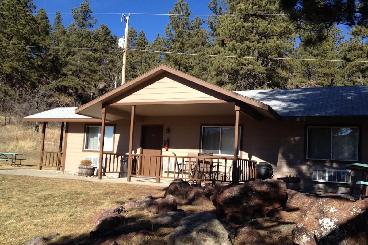 A single-story building with a porch, a fire hydrant, and a picnic table in the foreground.