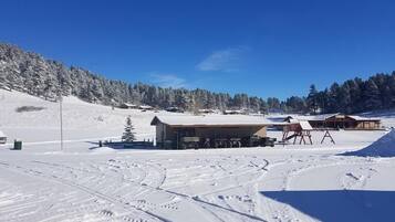 A snow-covered ski resort with buildings, ski lifts, and tracks.