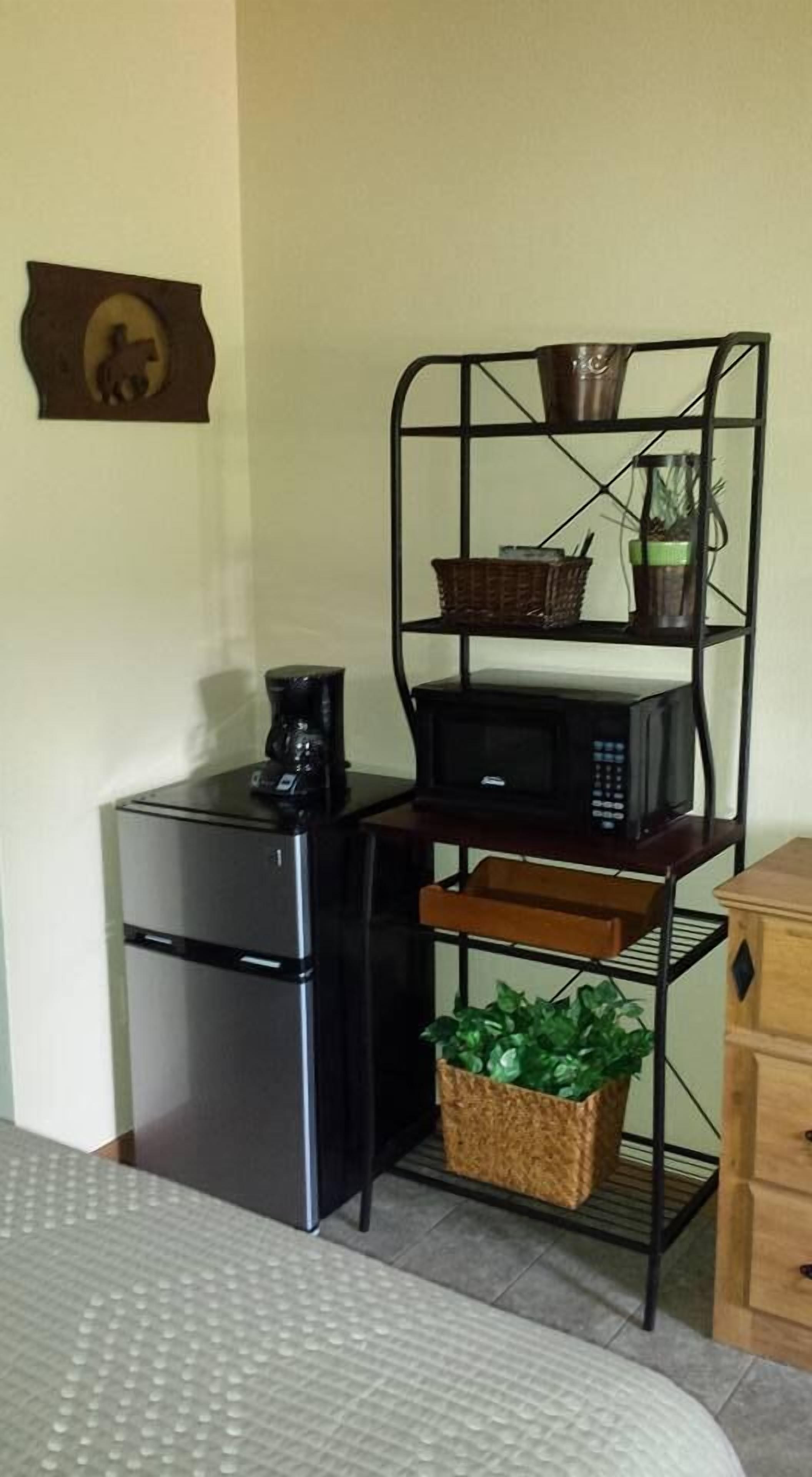 A compact kitchenette with a refrigerator, microwave, and coffee maker.