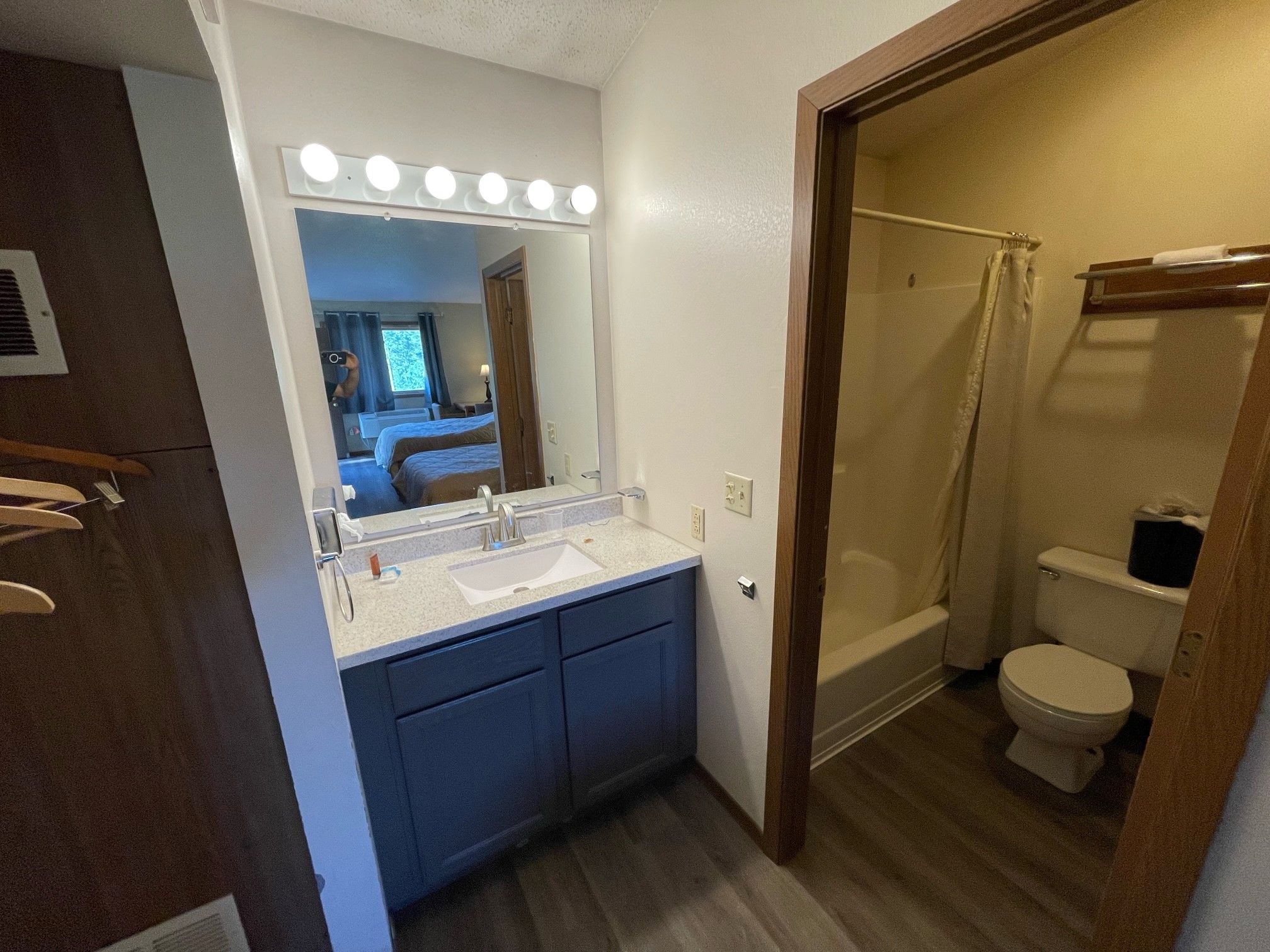 Une salle de bain comprenant un meuble-lavabo, un évier, un miroir et un espace douche.