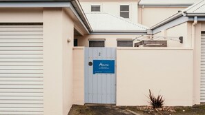 A gated property with a sign for Hearn's Port Fairy Accommodation, a number 2, and a small plant in the foreground. - Moyne Views 2 - Overlooking The Edge Of The Moyne River (Port Fairy)