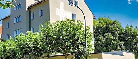 A multi-story building with a large sign reading 'POST' on the facade.