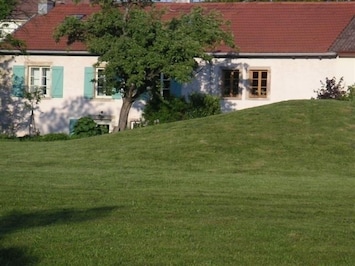La maison dans son jardin, au lever du soleil.