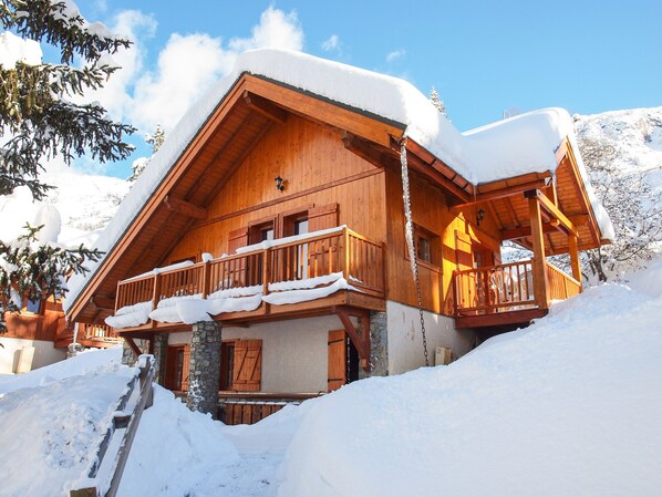 Eine Holzhütte mit Balkon, umgeben von Schnee.