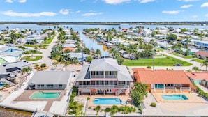 Zona residencial costera con varias casas, un puerto deportivo y piscinas.