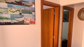 Ein Essbereich mit einem Holztisch, schwarzen Stühlen und violetten Untersetzern. An der Wand über dem Tisch hängt ein Poster.