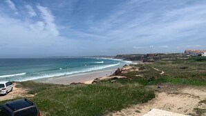 Eine Küstenlandschaft mit Strand, Klippen und einem Weg zum Meer.
