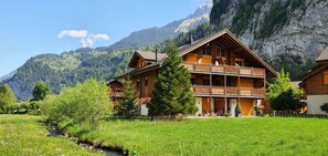 A wooden chalet with a balcony, set against a mountainous backdrop. - Apartment Arven - 3 Bedroom - 2 Bathroom - Uninterrupted mountain view (Lauterbrunnen)