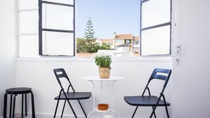 A small balcony with two black chairs, a white table, and a potted plant. - Lisbon Amazing Castel View (Lisboa)
