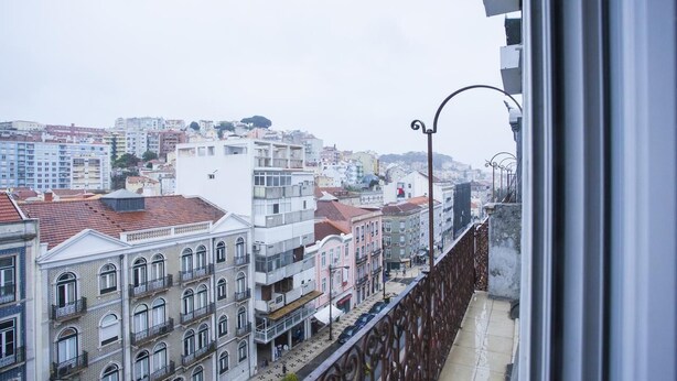 A cityscape with buildings, a street, and a balcony railing. - Lisbon Amazing Castel View (Lisboa)