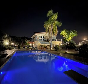 Una piscina cubierta, una piscina al aire libre, tumbonas